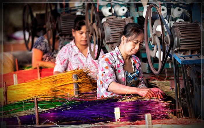 People weave mats using industrial mat weaving machines