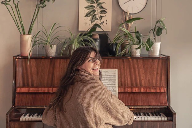 Attractive young woman playing the piano at home