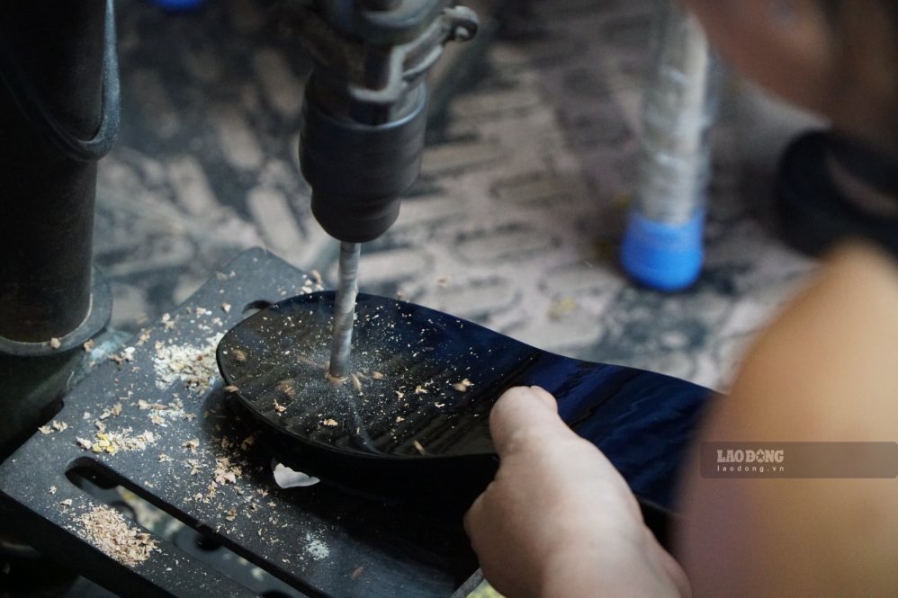 Người thợ tỉ mỉ khoan lỗ, đóng quai và hoàn thiện đôi guốc. Ảnh: Ngọc Ánh